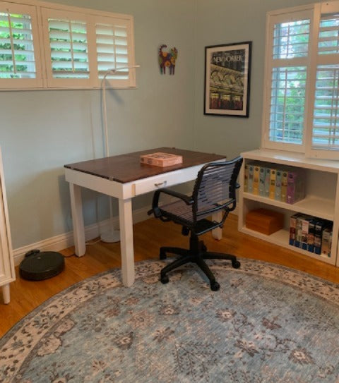 Home office with a jigsaw puzzle desk, chair, and bookshelf.