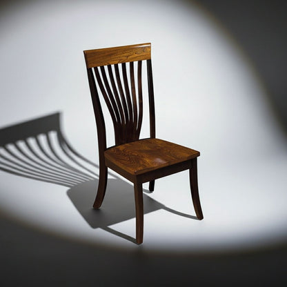 A dark brown wooden dining chair with a slatted back, shown on a white studio background with a dramatic spotlight and shadow.