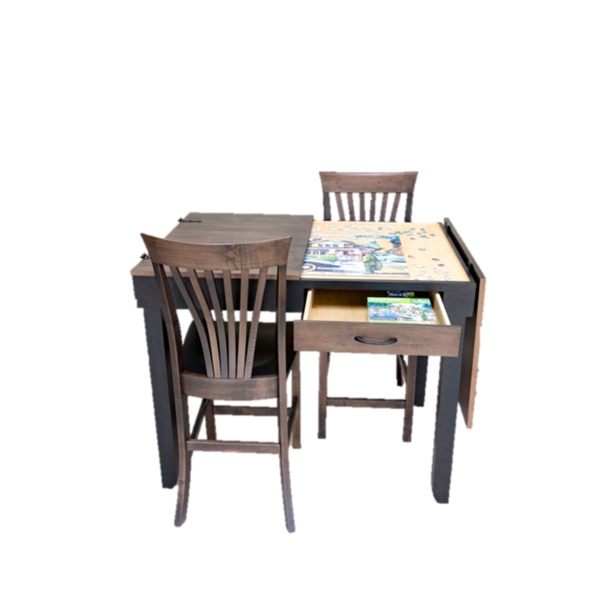 A dark wood jigsaw puzzle table with two matching wooden chairs, featuring a recessed jigsaw puzzle playing area and an open drawer holding jigsaw puzzle pieces with a plain white background.