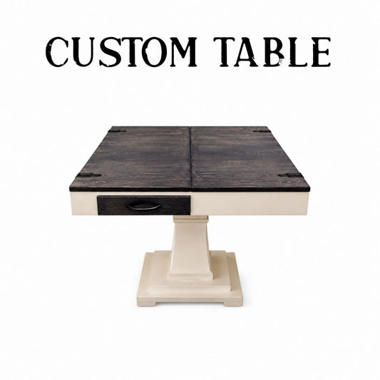 A custom square jigsaw puzzle table with a dark stained wood top, a single drawer with a black pull, and a cream-colored pedestal base. The text 'CUSTOM TABLE' is displayed at the top of the image on a solid white background.