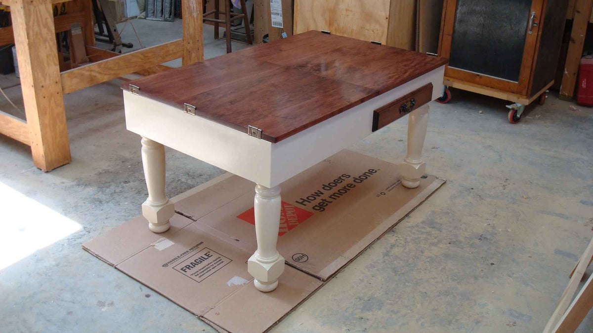 Wooden diy jigsaw puzzle table on a cardboard box in a garage setting