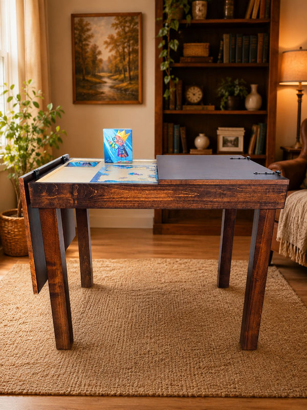 A rustic dark wood jigsaw puzzle table set in a cozy, warmly lit living room with a bookshelf, potted plant, and woven rug.